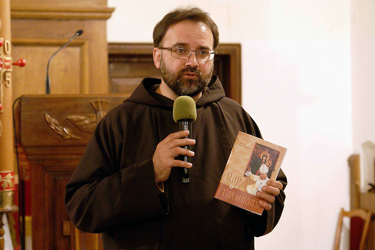 Proboszcz kościoła kapucynów o. Konstantyn Morozow OFM Cap prezentuje książkę Jana Pawła II Dar i Tajemnica