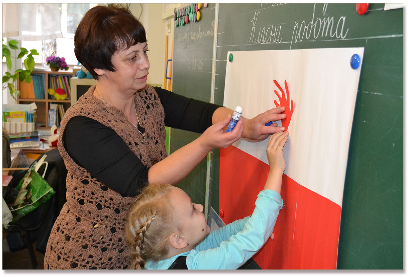 Na zdjęciu Pani Helena z Berdyczowa pomaga dzieciom tworzyć kompozycję patriotyczną