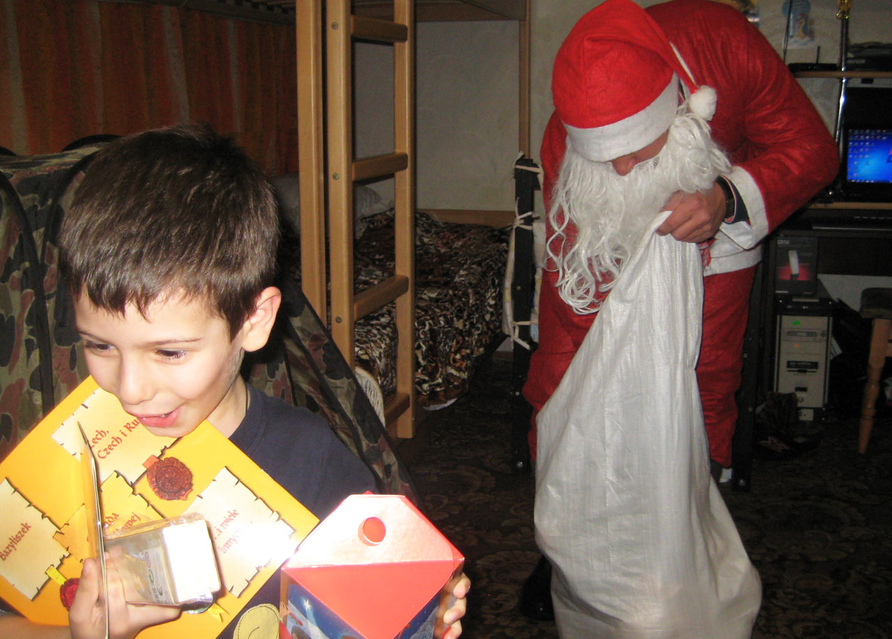 Na zdjęciu - mały Amir otrzymuje prezenty od Mikołaja